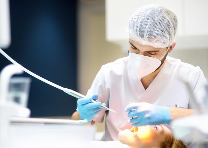 Dentist and patient at modern medical center. Doctor treats a young woman teeth in hospital. Practitioner examines the patient before orthodontists or prosthetics treatment. Hygiene and teeth healthy